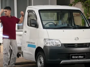Daihatsu Gran Max van komersial putih, terlihat dari sisi depan-samping di area parkir.