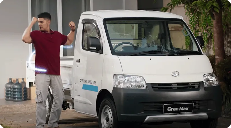 Daihatsu Gran Max van komersial putih, terlihat dari sisi depan-samping di area parkir.
