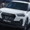 Eksterior depan samping mobil Daihatsu Rocky berwarna putih, terparkir di luar ruangan dengan desain modern.