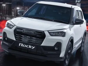 Eksterior depan samping mobil Daihatsu Rocky berwarna putih, terparkir di luar ruangan dengan desain modern.
